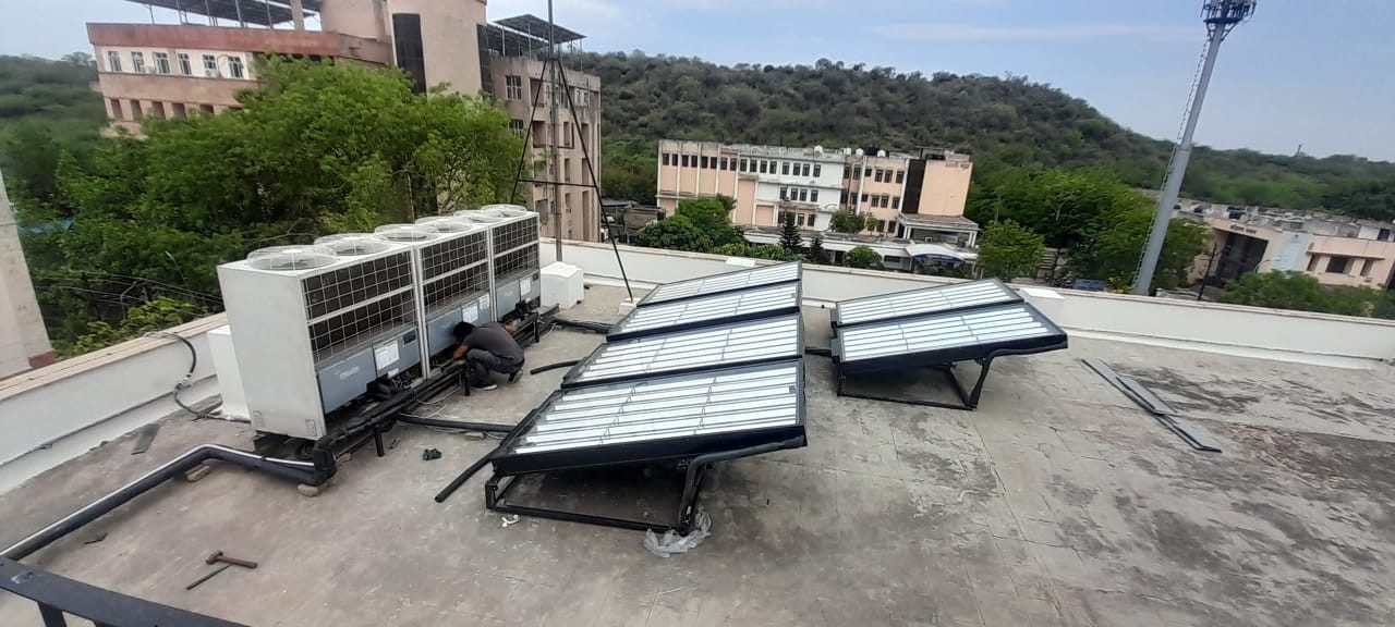Panels beside VRF outdoor units on a campus terrace